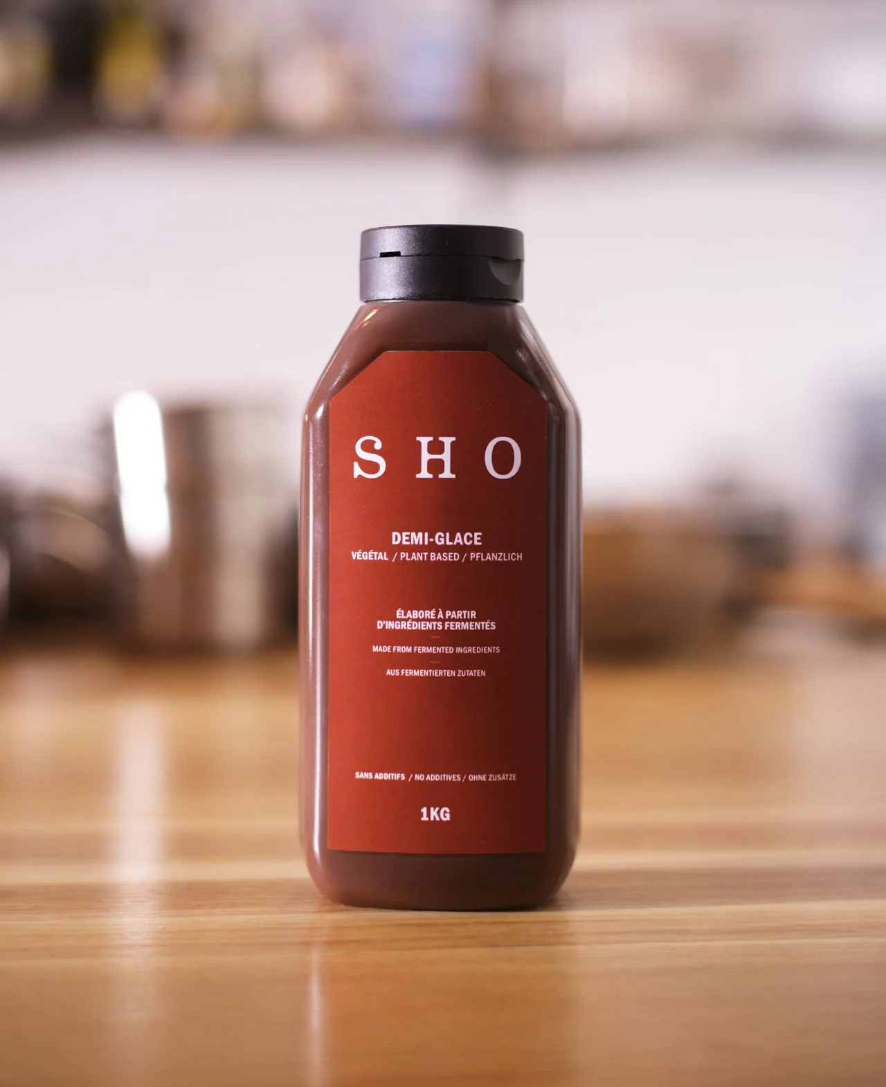 SHO Demi-Glace bottle on a wooden counter, a plant-based sauce made from fermented coffee, buckwheat and chickpeas