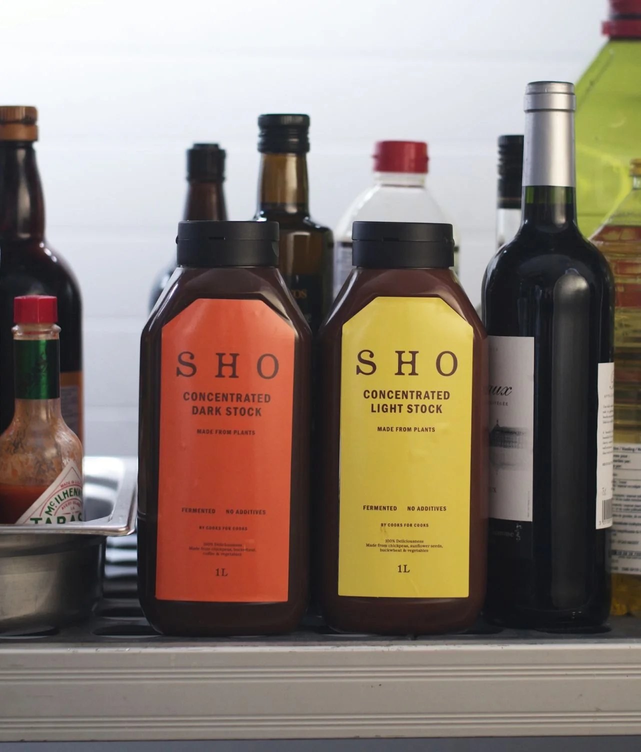 SHO Concentrated Dark Stock and Light Stock bottles on a kitchen counter for chefs