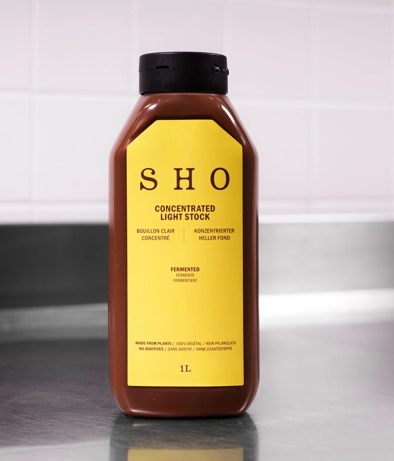 SHO Concentrated Light Stock bottle labeled as culinary bases in a kitchen setting