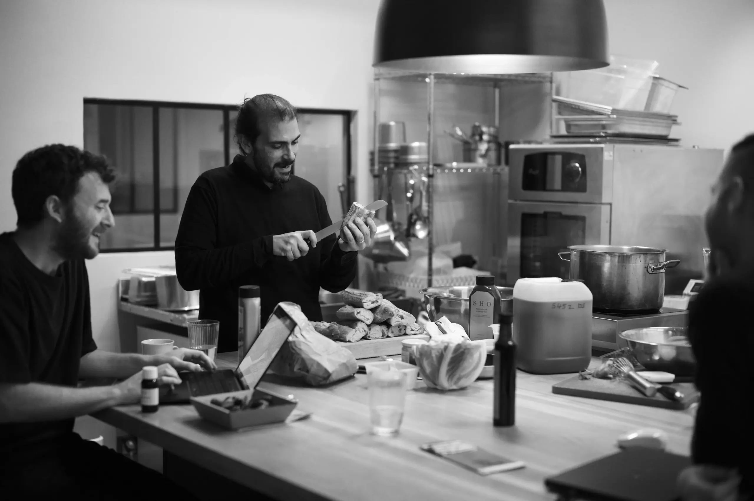 Équipe de cuisiniers travaillant ensemble dans une cuisine d'essai pour élaborer des bases aromatiques.